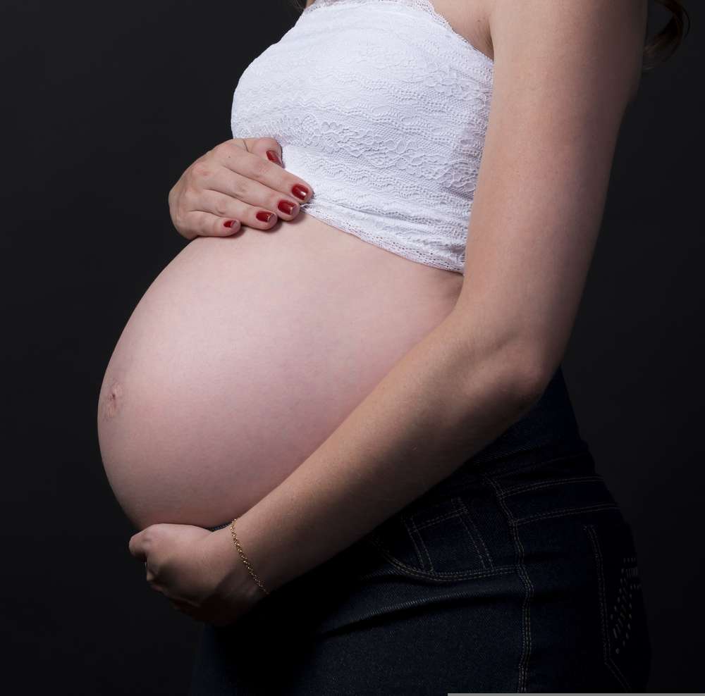 Zwangere vrouw die haar buik vasthoudt