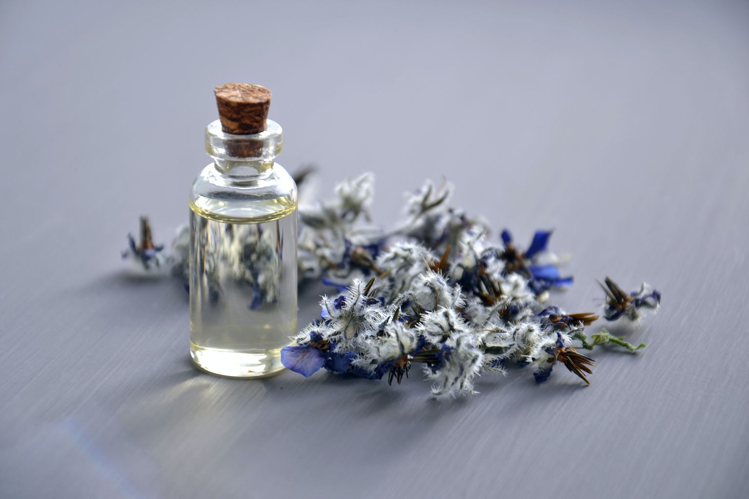 Flowers with small glass bottle. Inside is an aromatic oil.