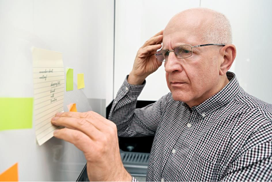 Homem idoso com demência olha para notas