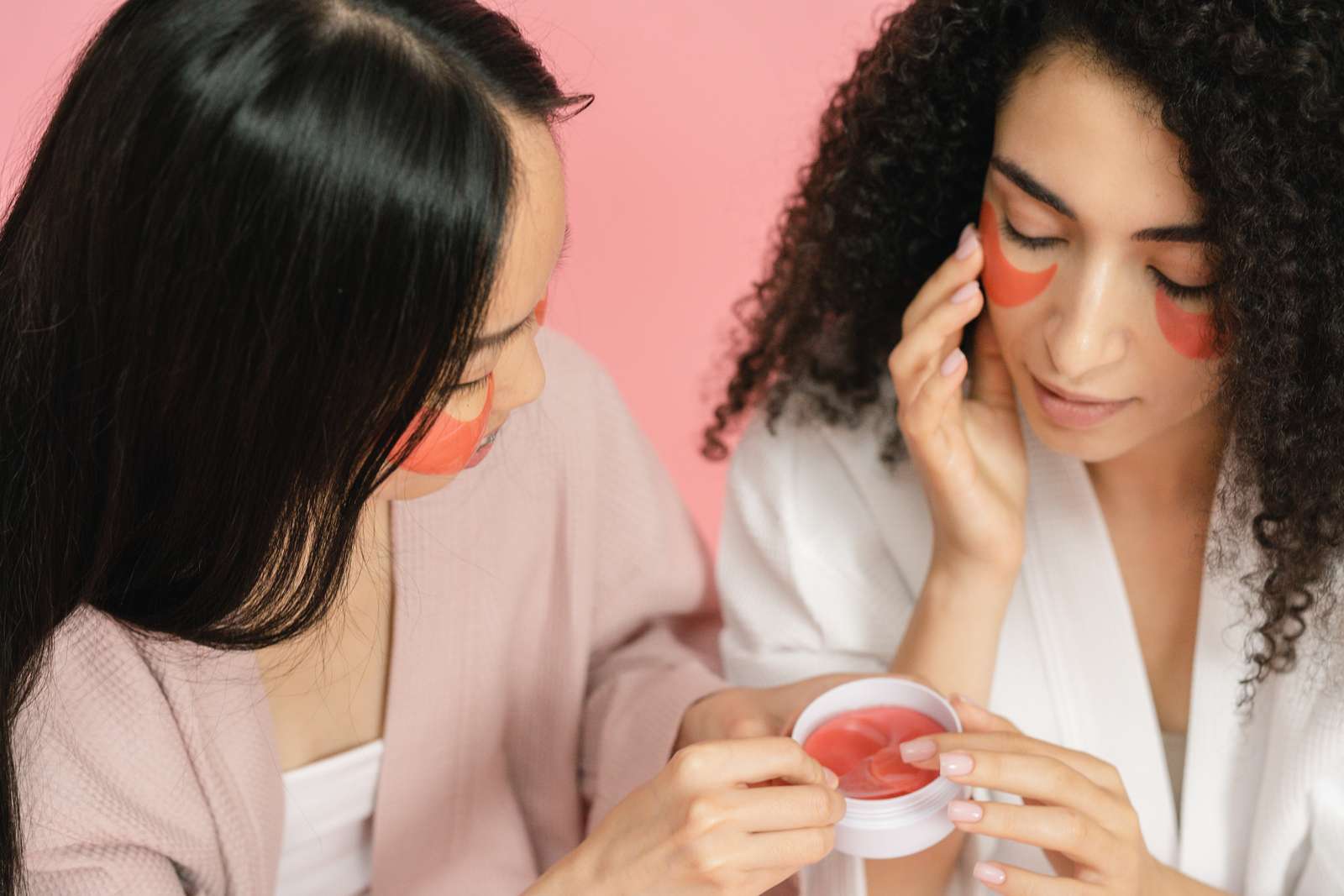rot frau frauen augen 9774961 Zwei Frauen tragen eine rote Creme unter die Augen auf.