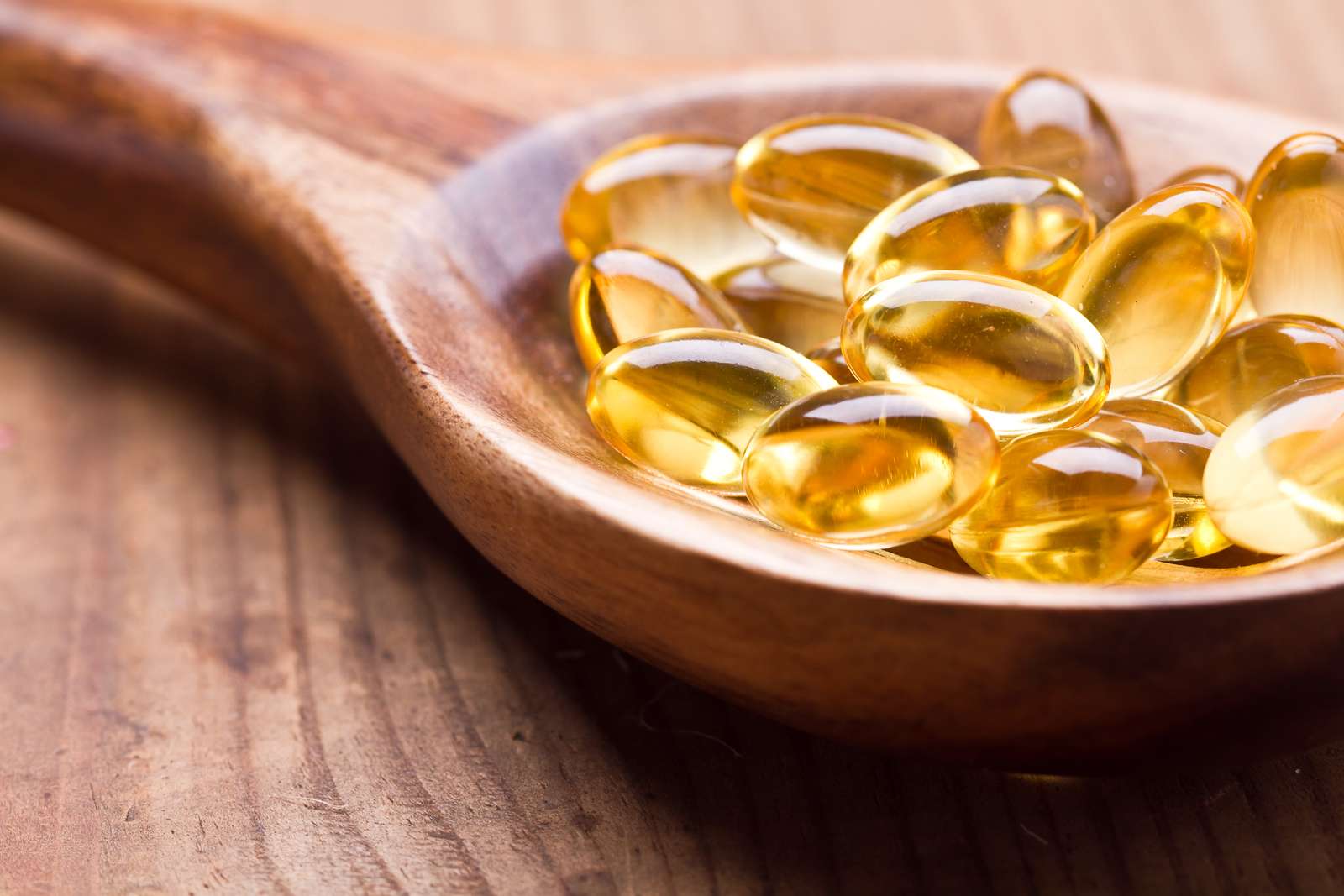 De omega 3 gelcapsules van de kabeljauwleverolie enig op houten achtergrond