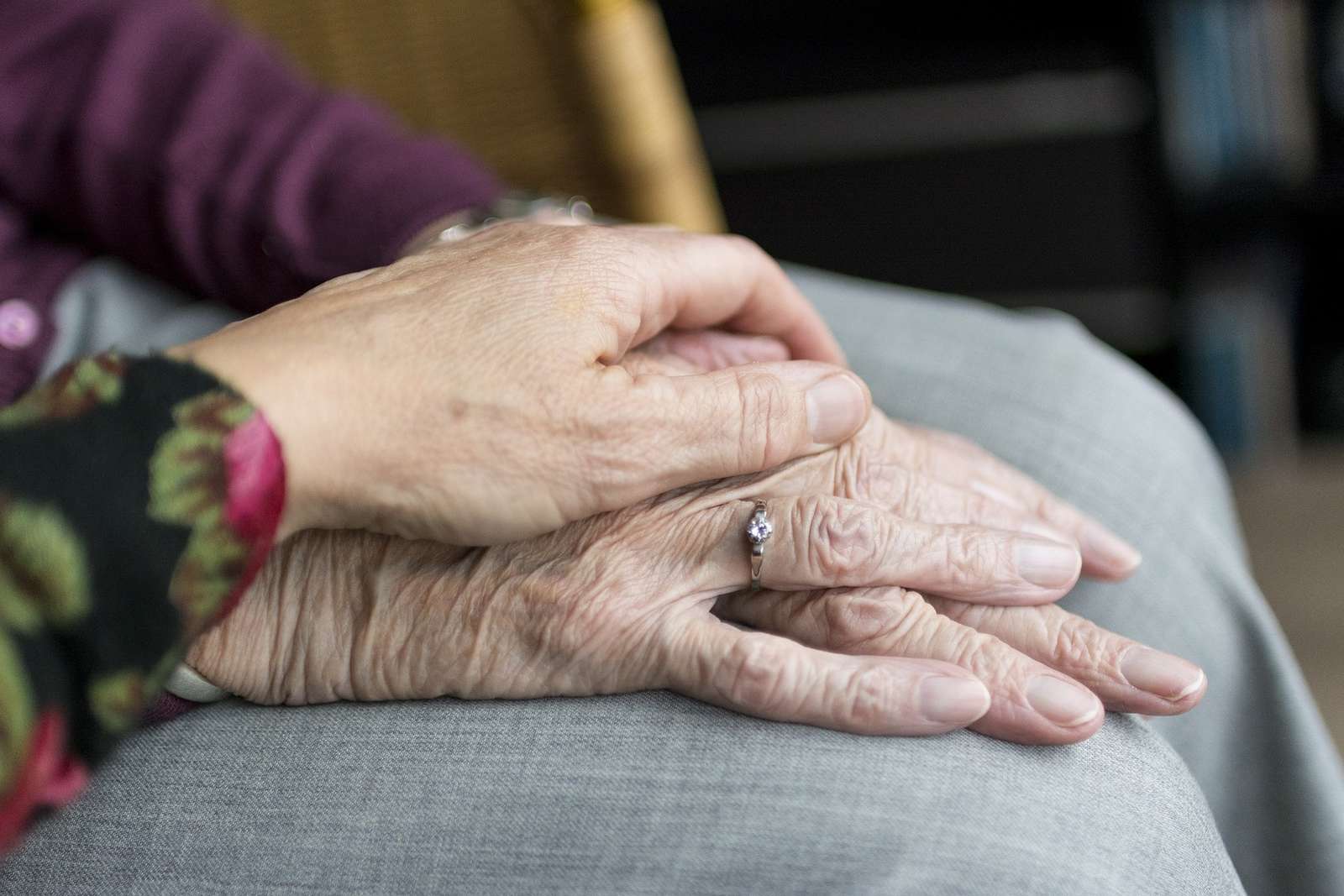 Jonge hand die de hand van een oudere vasthoudt
