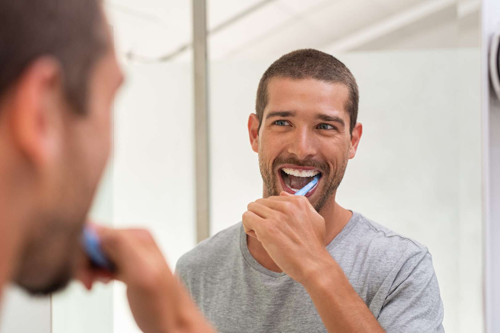 Happy man brushing teeth Lachender Mann der sich seine Zähne putzt