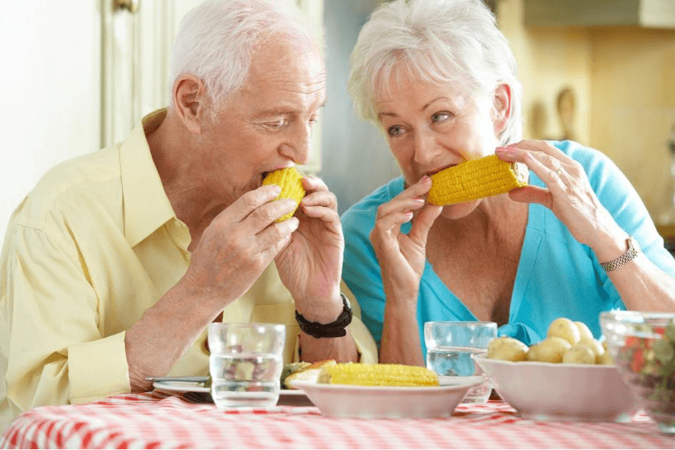 Casal de idosos a comer juntos na cozinha Casal de idosos come junto