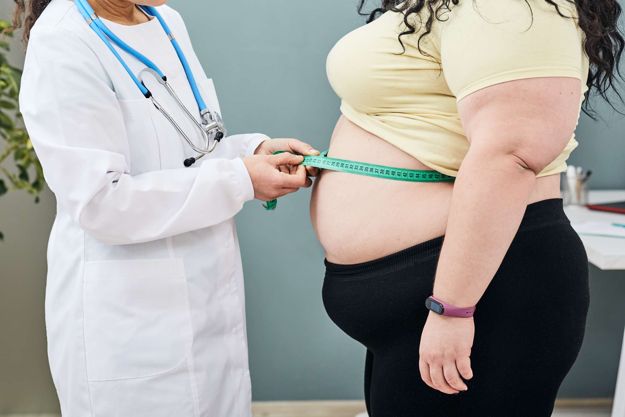 Obesidad Dietista de peso no saludable inspecciona la cintura de una mujer con una cinta métrica para prescribirle una dieta de adelgazamiento Sobrepeso (obesidad)