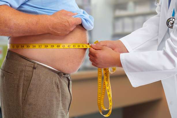 Médico midiendo un perímetro abdominal. Médico midiendo la grasa del cuerpo humano obeso. Obesidad y pérdida de peso.
