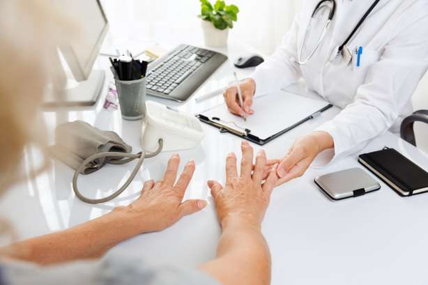 Examen médical avec une femme âgée qui montre ses mains au médecin. Gros plan d'un examen médical : une femme d'âge moyen souffrant d'arthrite montre ses mains à une femme médecin.